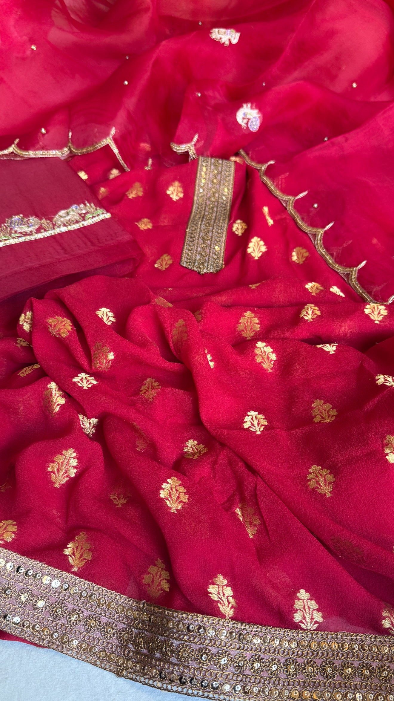 Crimson red banarasi gorgette kadhwa buti kurta paired with toy hathi motif kora silk scalloped duppata set