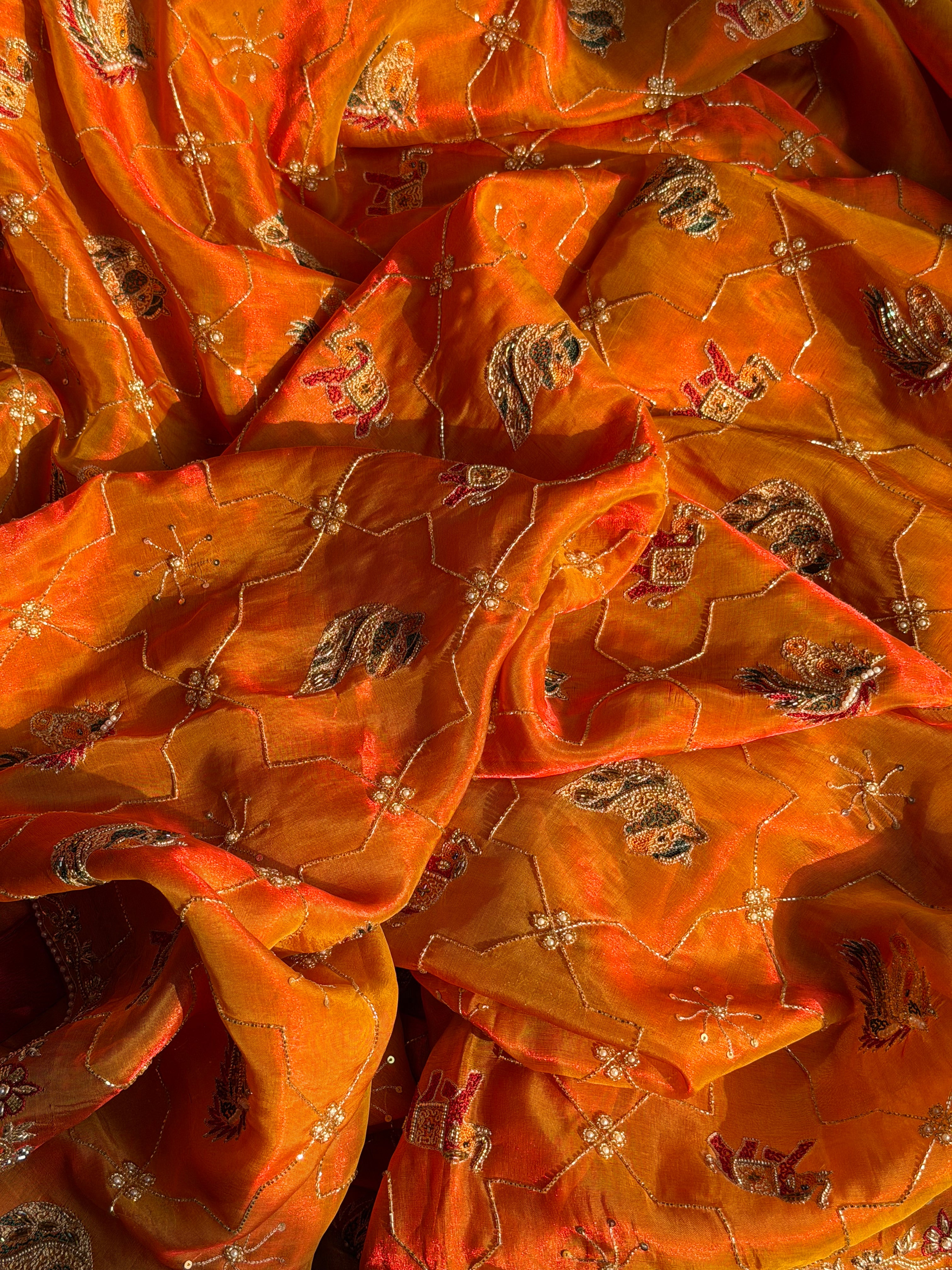 Husn edit shikargah animal motif kesar orange tissue silk hand embroidered saree