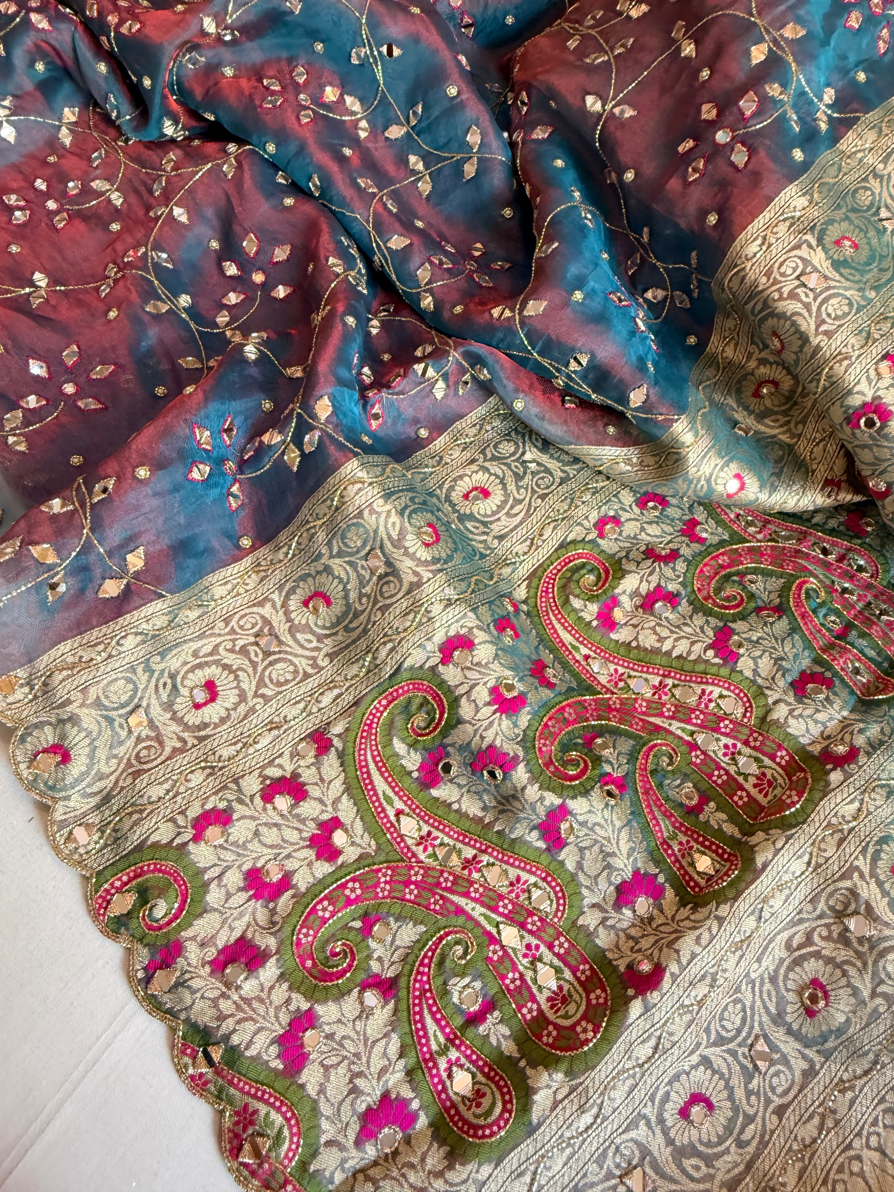 Reddish-blue dhup chao effect tissue silk meenakari mirror work hand embroidered saree