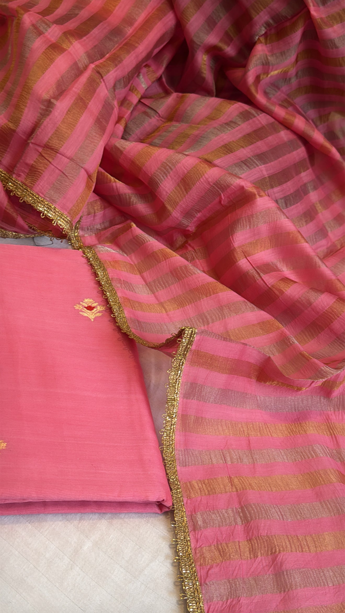 Peachy pink linen gorgette kurta paired with striped tissue silk duppata