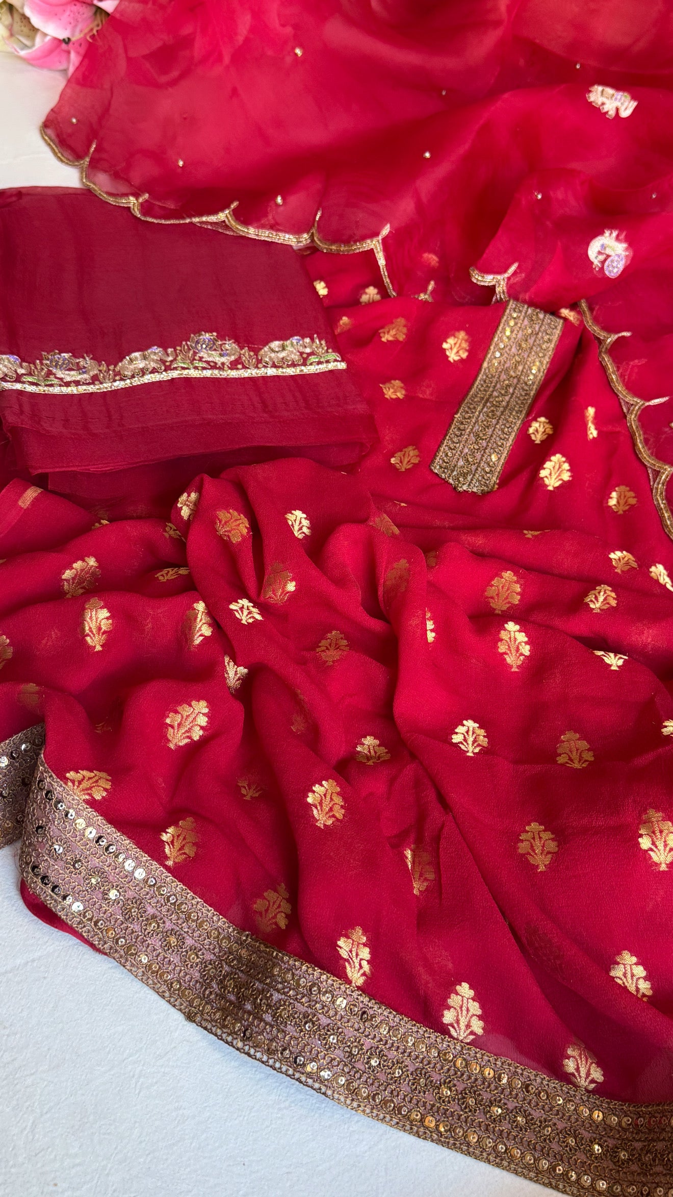 Crimson red banarasi gorgette kadhwa buti kurta paired with toy hathi motif kora silk scalloped duppata set