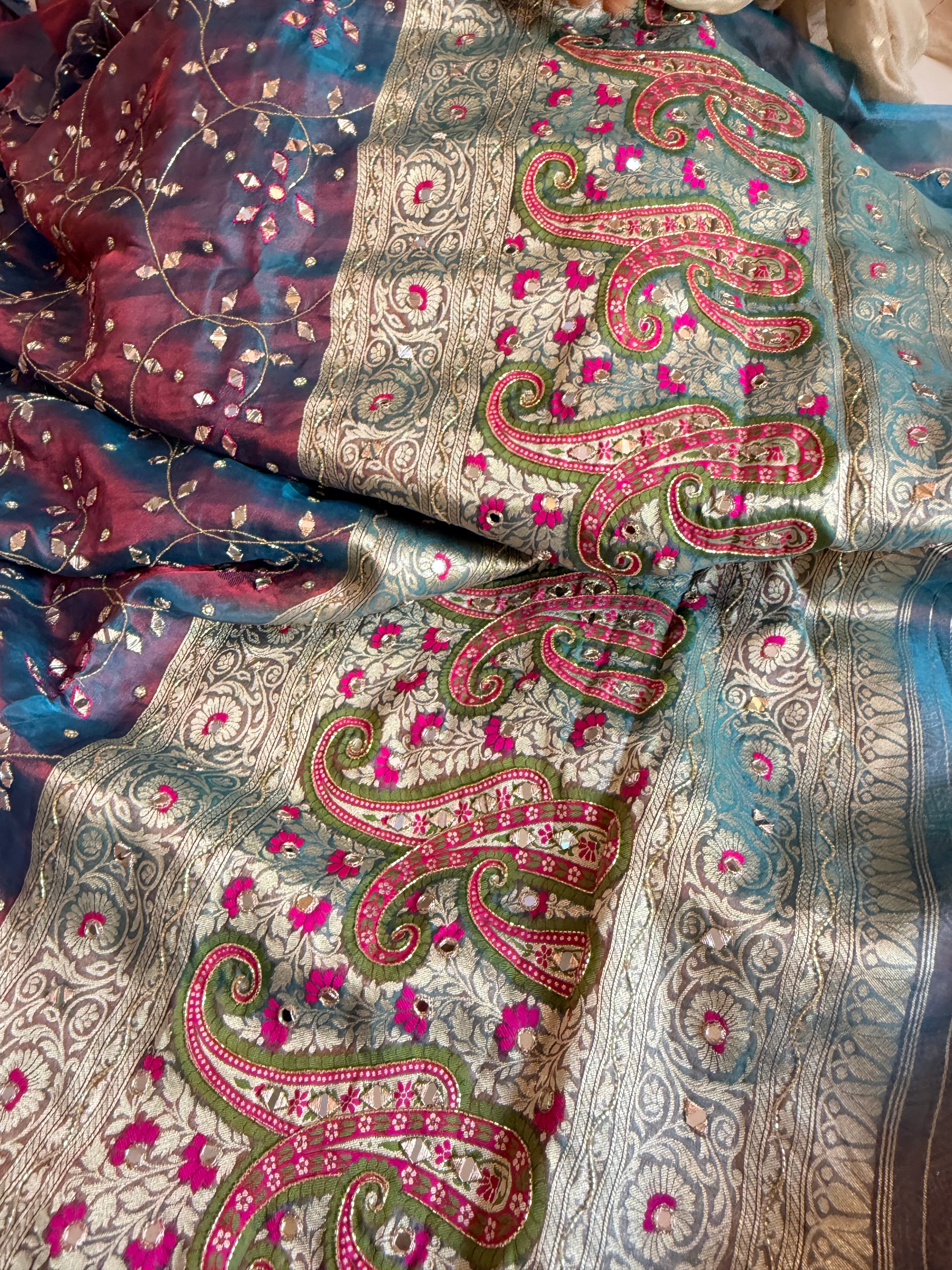 Reddish-blue dhup chao effect tissue silk meenakari mirror work hand embroidered saree