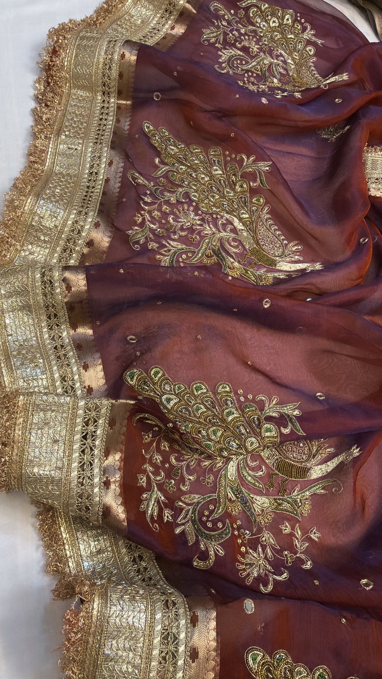 Maroonish-blue dhup chao effect tissue silk peacock motif hand embroidered saree