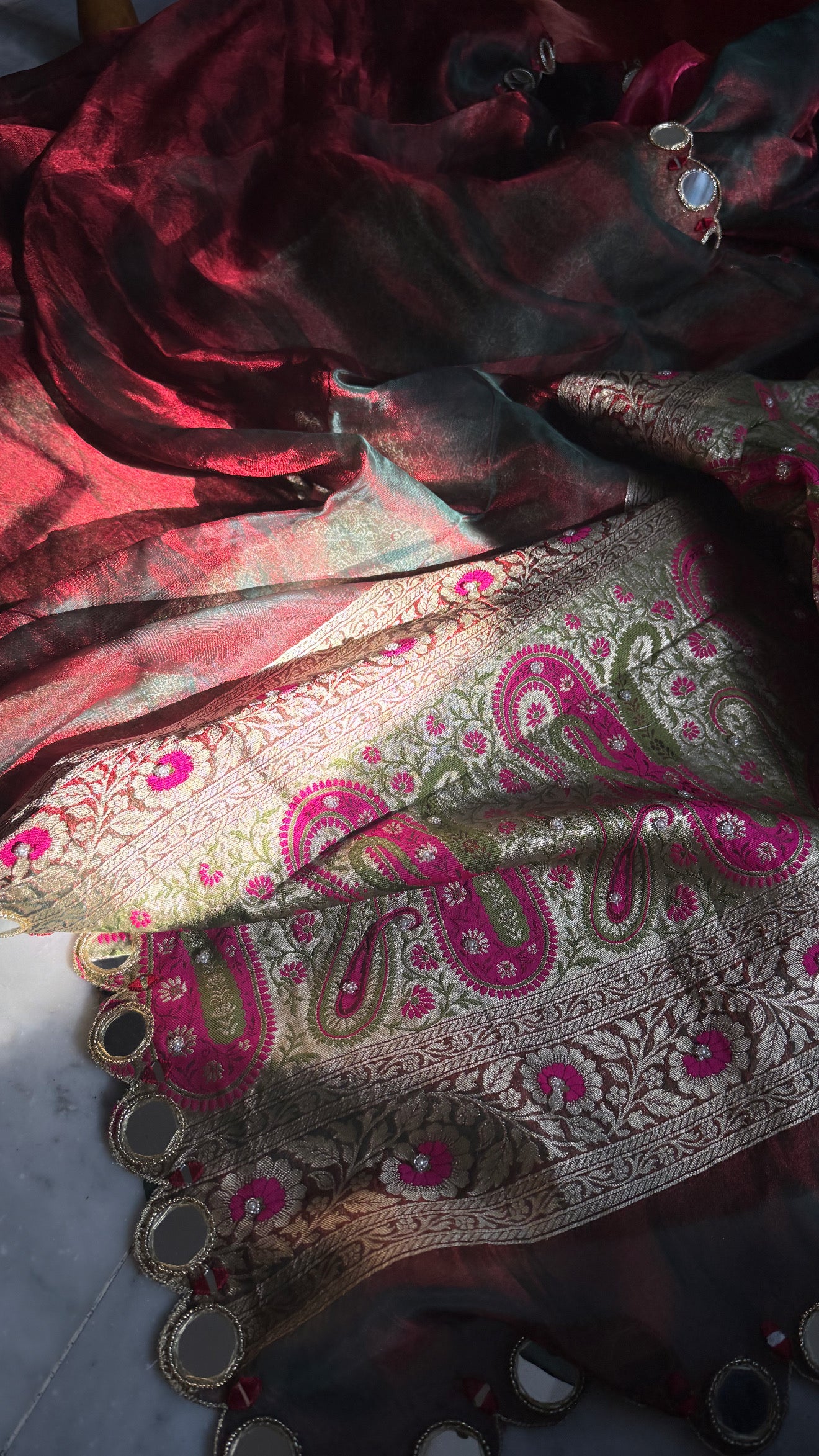 Teej special- Mirror work border maroonish red dhup chao effect tissue silk hand embroidered saree