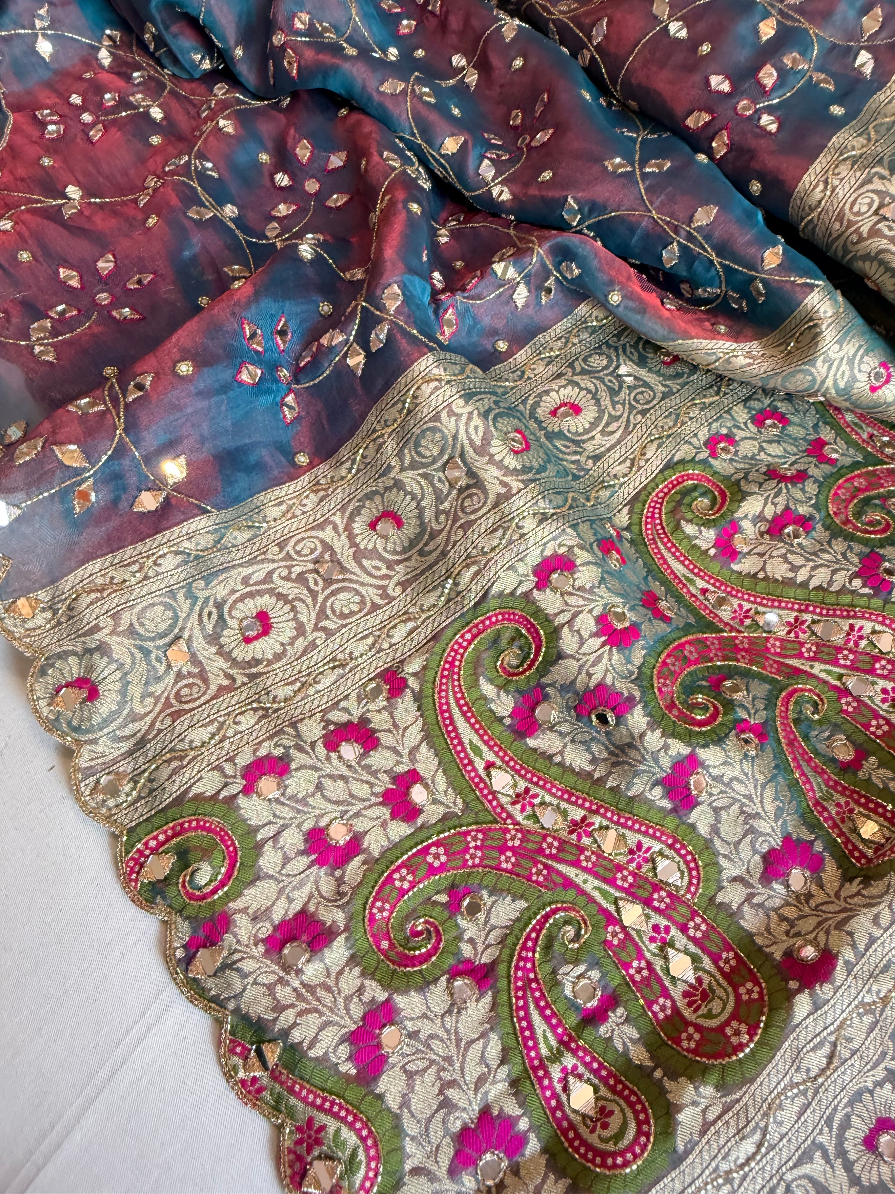 Reddish-blue dhup chao effect tissue silk meenakari mirror work hand embroidered saree