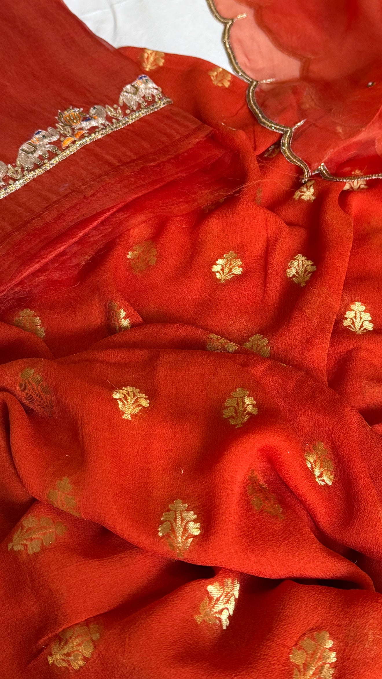 Burnt orange banarasi gorgette kadhwa buti kurta paired with toy hathi motif hand embroidered scalloped kora duppata